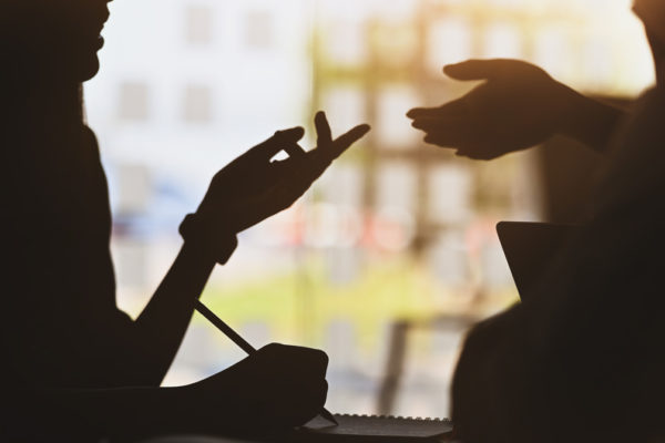 Silhouette picture of two people in a meeting